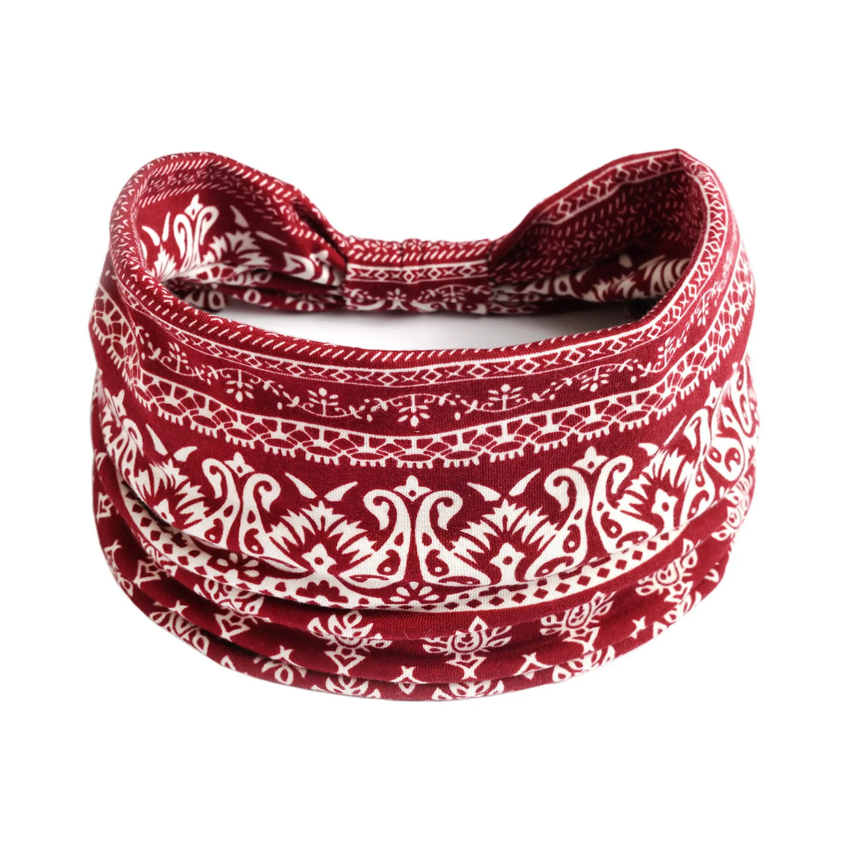A close-up of a red and white patterned bohemian cotton stretch headband rolled into a coil.