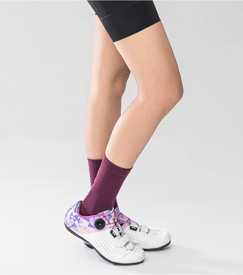 A person wearing purple socks and black leggings is shown in a side view.