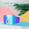 A pair of blue and purple tinted sunglasses resting on a light blue surface with tropical leaves in the background.