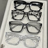 A collection of five square anti-blue light eyeglasses displayed in a white box.
