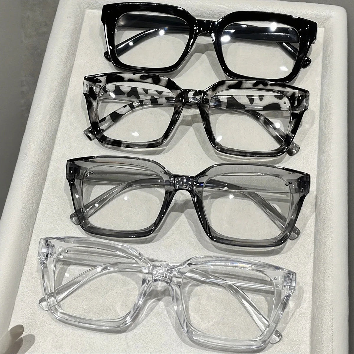A collection of five square anti-blue light eyeglasses displayed in a white box.