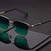 A pair of classic square metal frame sunglasses with dark green lenses resting on a black surface.