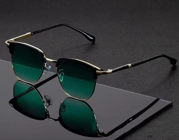 A pair of classic square metal frame sunglasses with dark green lenses resting on a black surface.