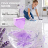 A glass bowl filled with purple floor cleaning tablets and soapy water on a white tiled floor.