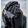 A close-up of black leather motorcycle riding gloves being placed on a helmet.