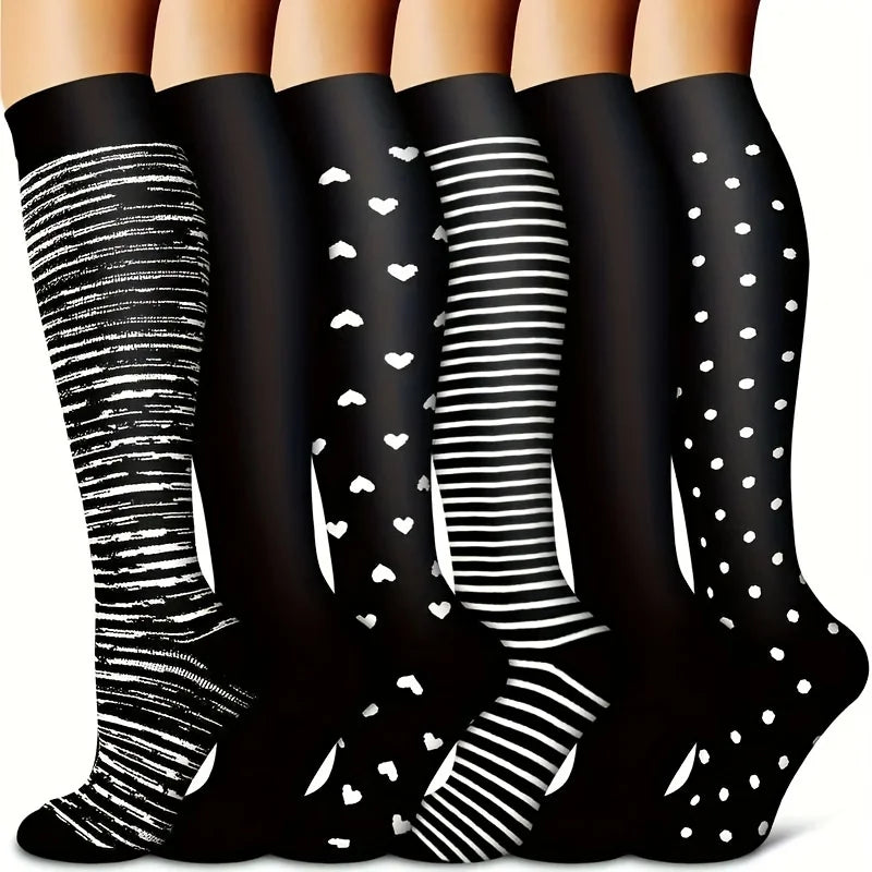 A set of black knee-high compression socks featuring various white patterns including stripes and polka dots.
