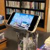 A smartphone displaying a scenic view is placed on top of an insulated sports water bottle.