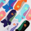 A variety of colorful massage and compression running socks for men laid out on a white background.