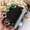 A hand holds a black heating patch with various herbs and spices visible through clear domes.