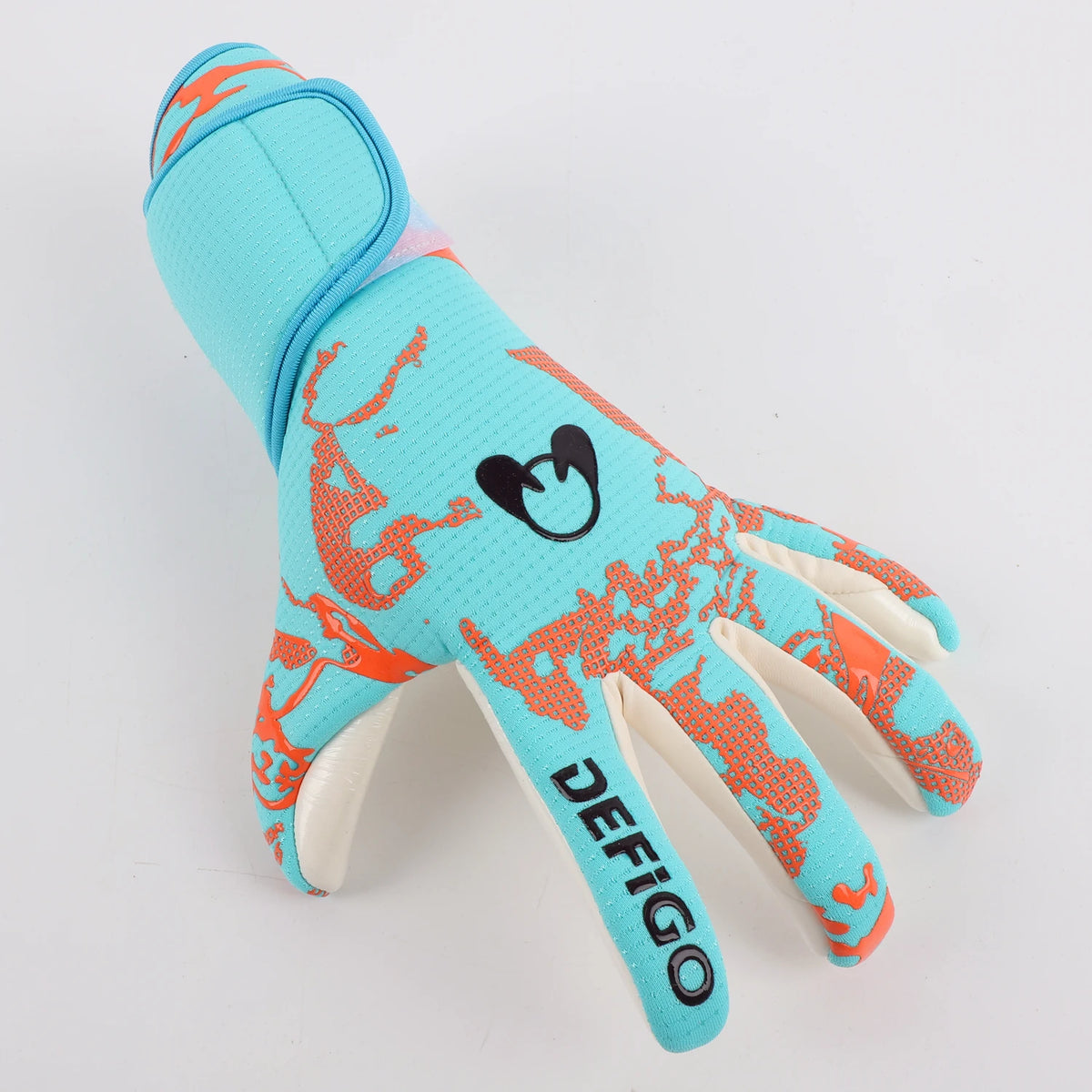 A bright cyan goalkeeper glove featuring an orange pattern and the word Defigo on the palm.
