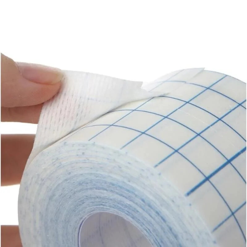 Una mano está quitando un rollo de cinta adhesiva médica no tejida blanca.