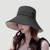 A woman wearing a dark gray double-sided wide brim bucket hat for sun protection.
