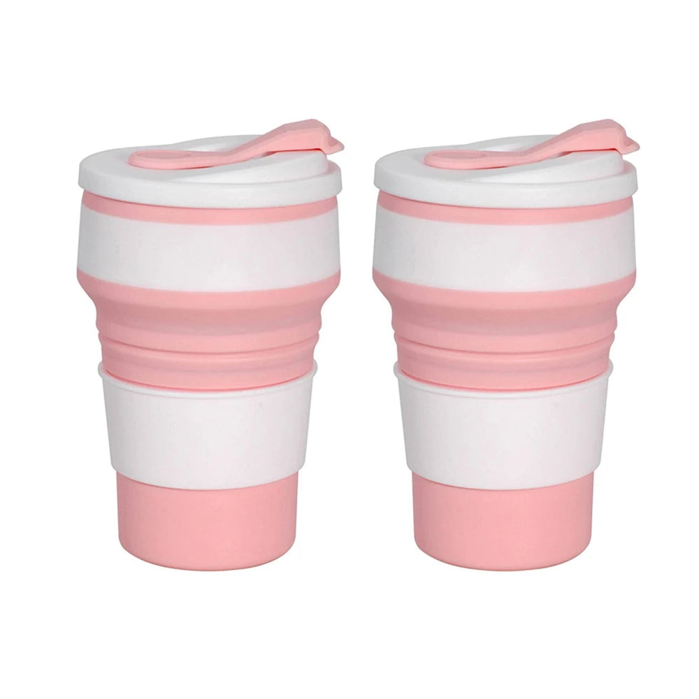 A pair of reusable silicone collapsible coffee cups with lids in white and pink.