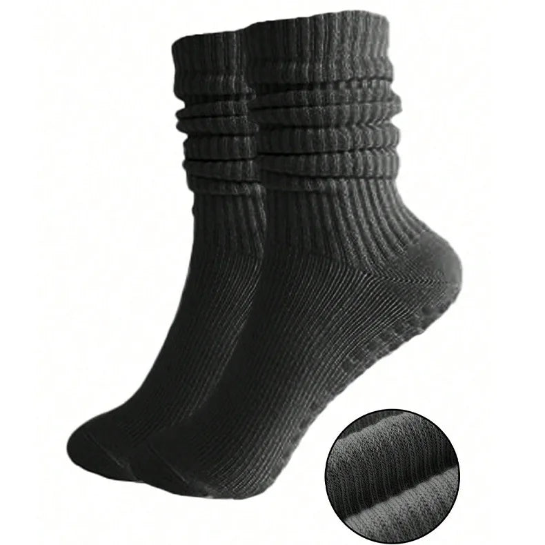 A set of three black silicone pilates and yoga socks stacked vertically.