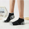 A pair of black and gray athletic mesh ankle socks lying on a white surface.