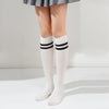 White cotton knee high socks with black stripes worn by a person.