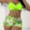 A model wears a neon yellow crop top and matching floral print bikini bottoms.
