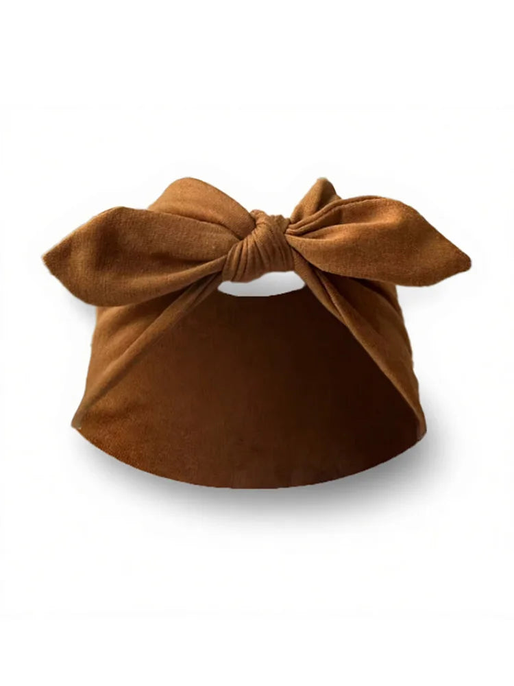 Un bandeau élastique en daim marron noué en nœud, montré sur fond blanc.