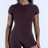 A woman wearing a seamless high-waist yoga set in a deep plum color.