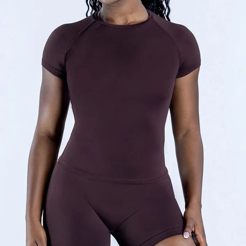 A woman wearing a seamless high-waist yoga set in a deep plum color.