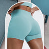 Un mannequin porte des short de yoga compressifs bleu clair taille haute, mettant en valeur la coupe et le confort du tissu.