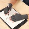 A hand wearing a gray fingerless compression glove is writing on a clipboard with a pen.