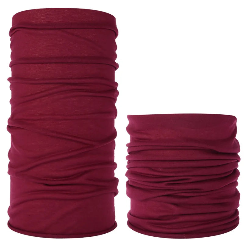 A stack of deep burgundy seamless fabric headbands and balaclavas rolled into cylindrical shapes.