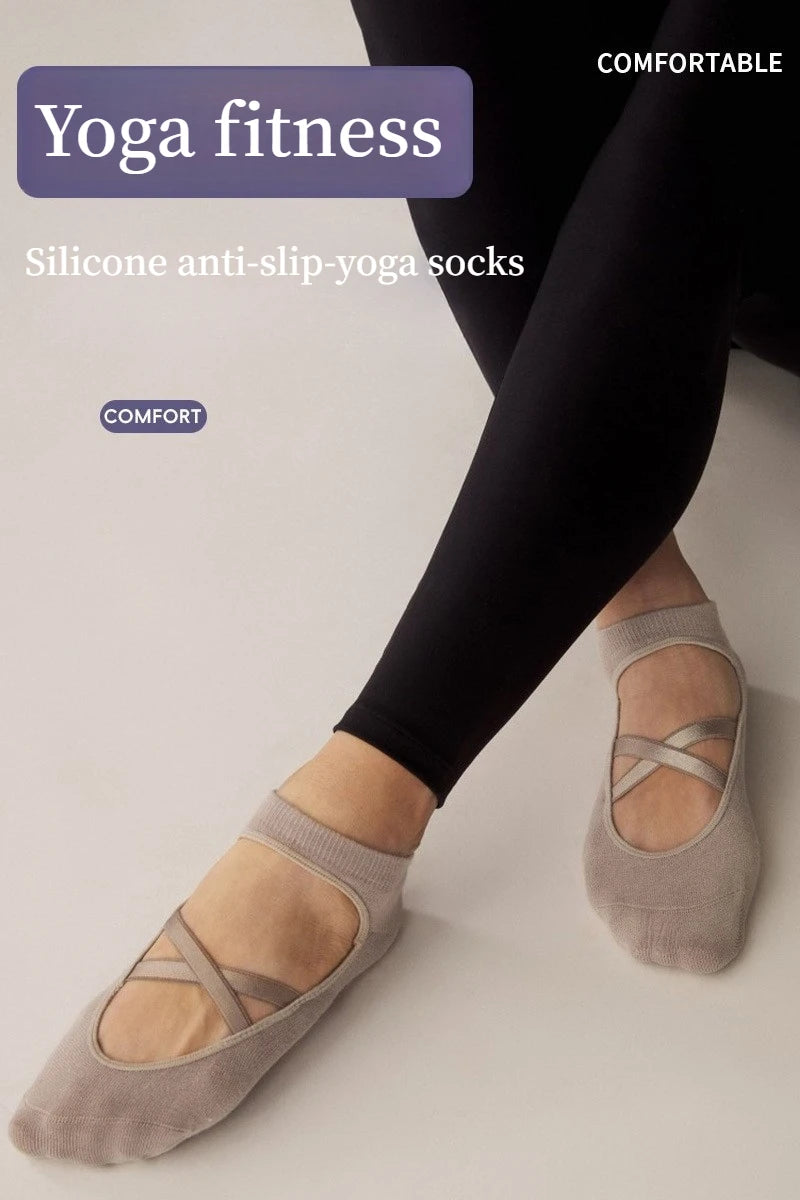 A close-up of gray silicone anti-slip yoga socks being worn on a foot against a light background.