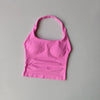 Haut sans coutures rose vif pour femmes, col halter, pour yoga et fitness, sur fond gris clair.