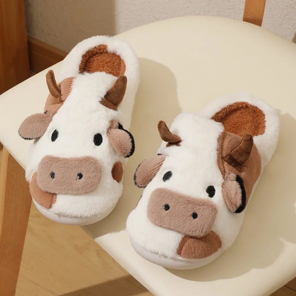 Pair of cartoon cow winter home slippers with white fur and brown accents