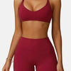 A model wearing a maroon high-support sports bra and matching shorts for fitness.