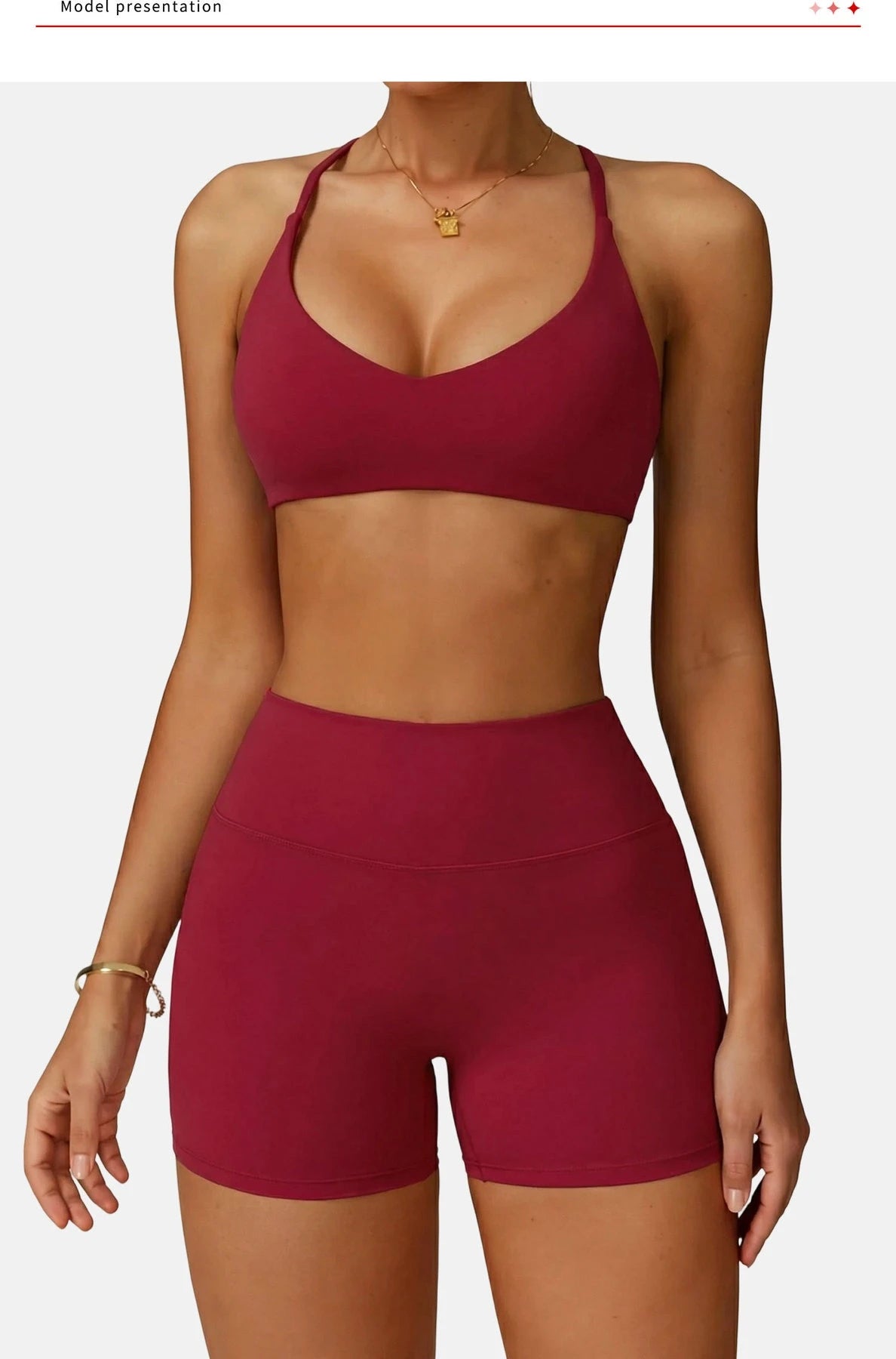 A model wearing a maroon high-support sports bra and matching shorts for fitness.