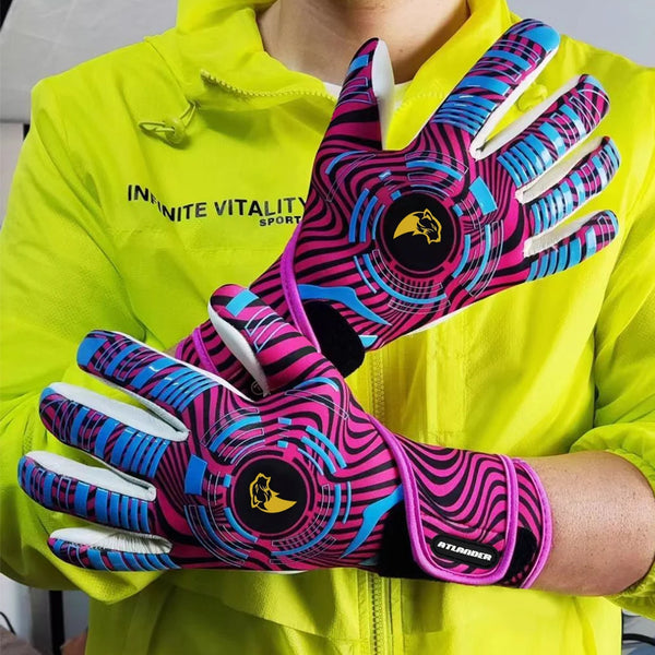 A hand wearing vibrant pink and black patterned goalkeeper gloves is shown against a bright yellow jacket.