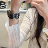 A close-up of a hand wearing a black and white leopard print silicone watch band on a wrist.