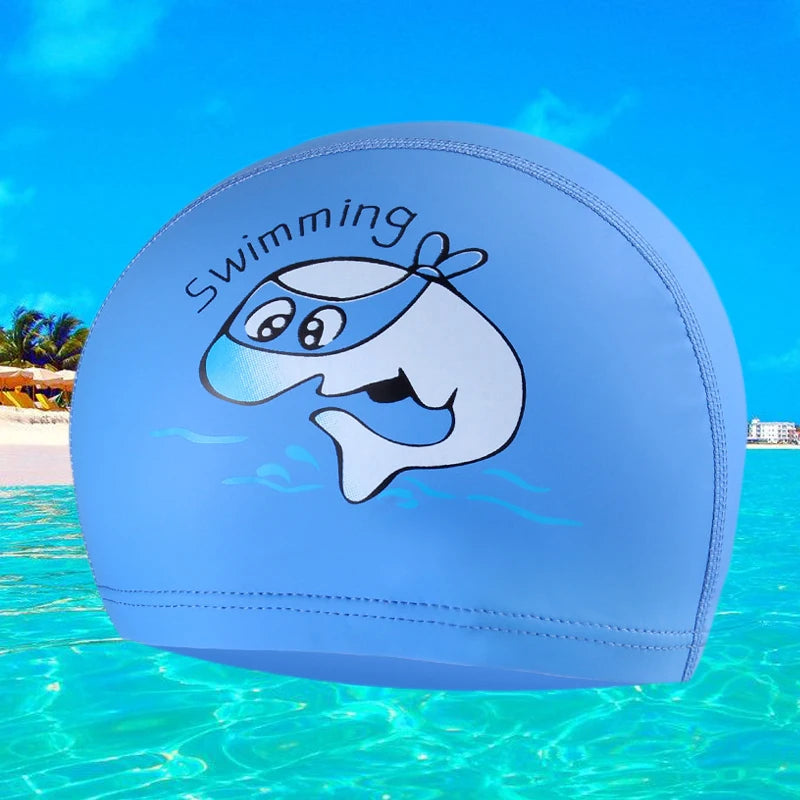A light blue swimming cap featuring a cartoon whale design floating in clear water.