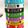 A stack of colorful silicone religious cuff bracelets featuring the word JESUS and a heart design.