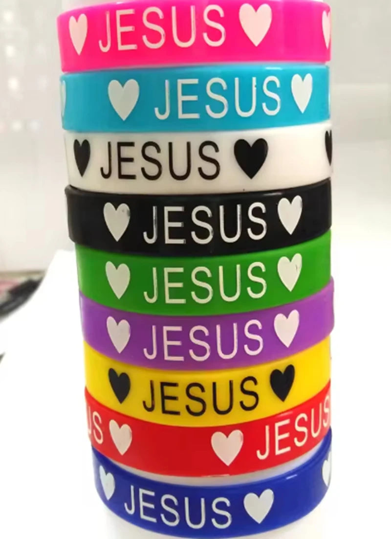 A stack of colorful silicone religious cuff bracelets featuring the word JESUS and a heart design.