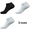Tres pares de calcetines deportivos de algodón gris claro y negro, vistos de lado.