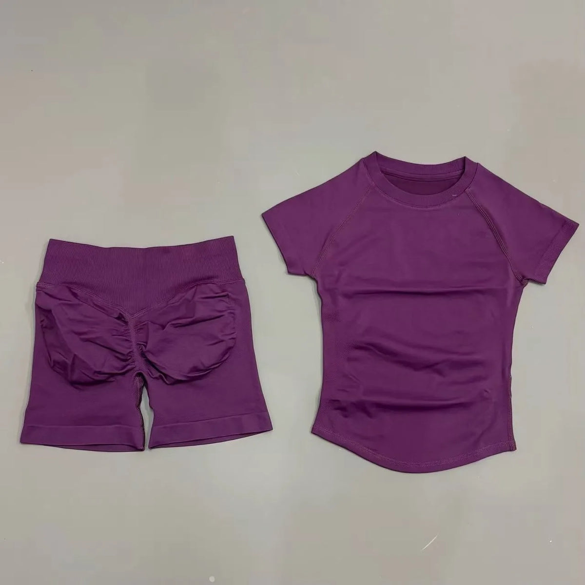 A purple seamless yoga set for women featuring a short sleeve top and workout leggings.