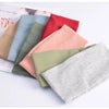 A collection of soft cotton knitted headbands in various pastel and earthy tones laid out on a white surface.
