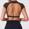 A woman wearing a dark brown women's fitness crop top yoga and gym t-shirt, shown from the back.