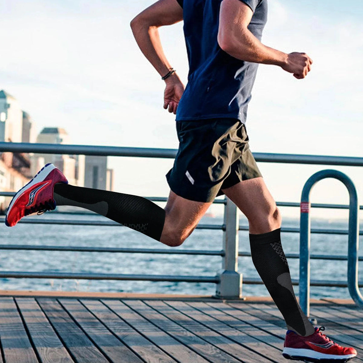 A person running outdoors wearing black compression socks and athletic clothing.