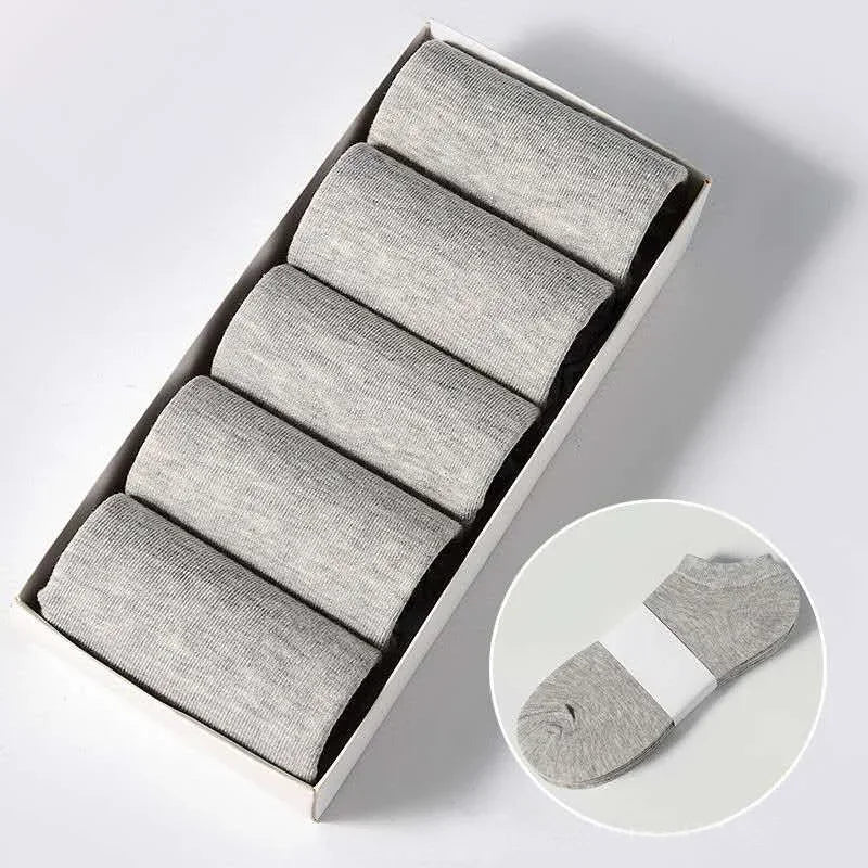 Una caja con varios pares de calcetines unisex de algodón transpirable y color gris claro.