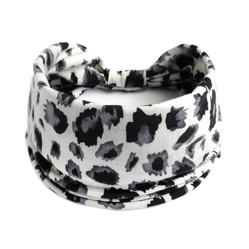 A black and white leopard print cotton stretch headband tied around the head.