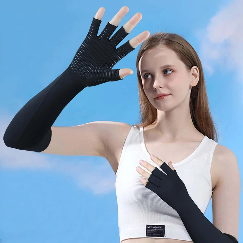 A woman models black compression gloves on her hand against a light blue sky background.