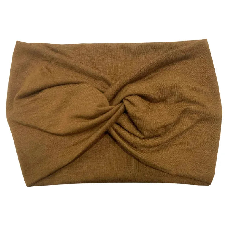 A brown women's elastic sports headband folded into a knot.