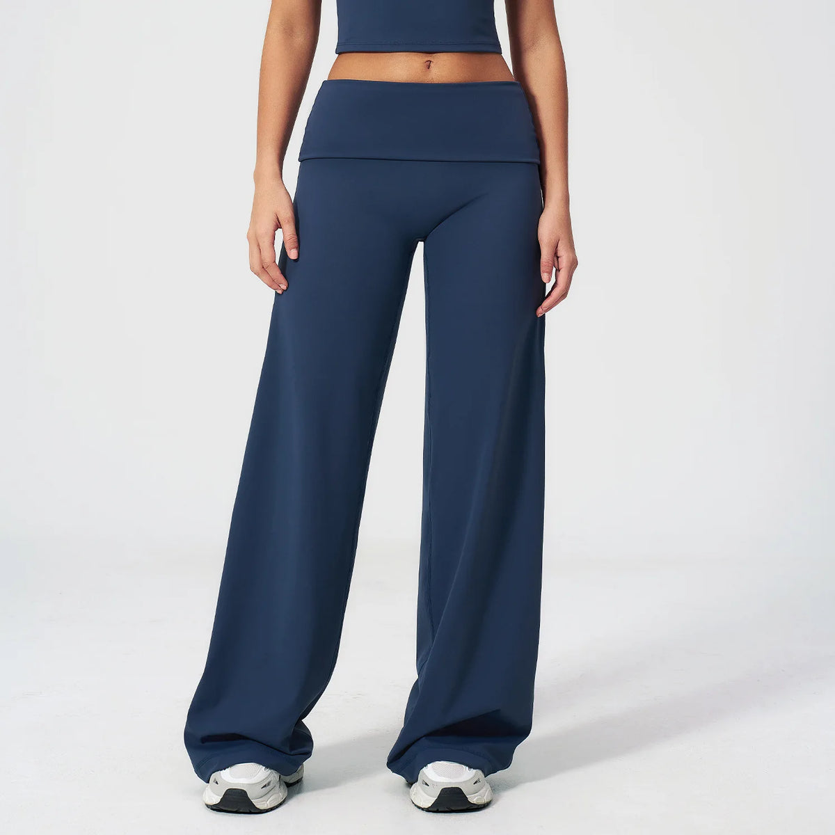 A model wearing navy blue flared high-waist yoga pants and a matching crop top.