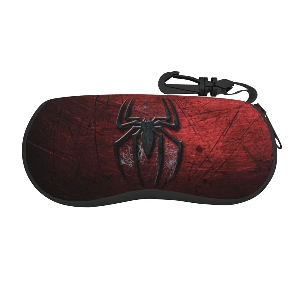 A dark red leather pouch with a black spider web design and a black strap.