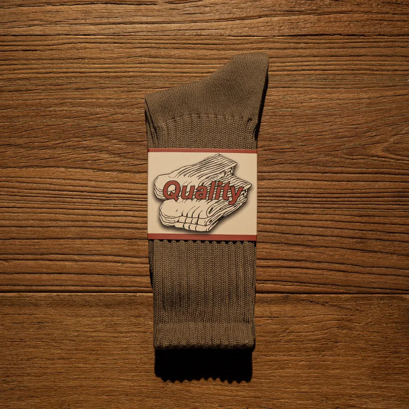 A pair of brown thick cotton tube socks with a white label featuring the word Quality.
