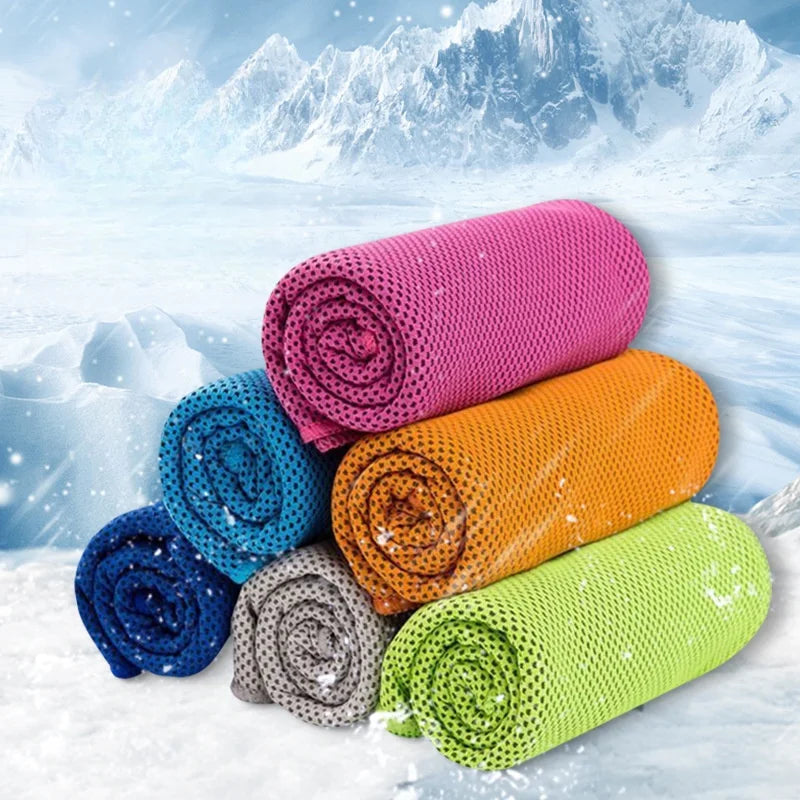 Une pile de serviettes de refroidissement circulaires colorées (rose, orange, bleu, gris et vert lime) devant une montagne en